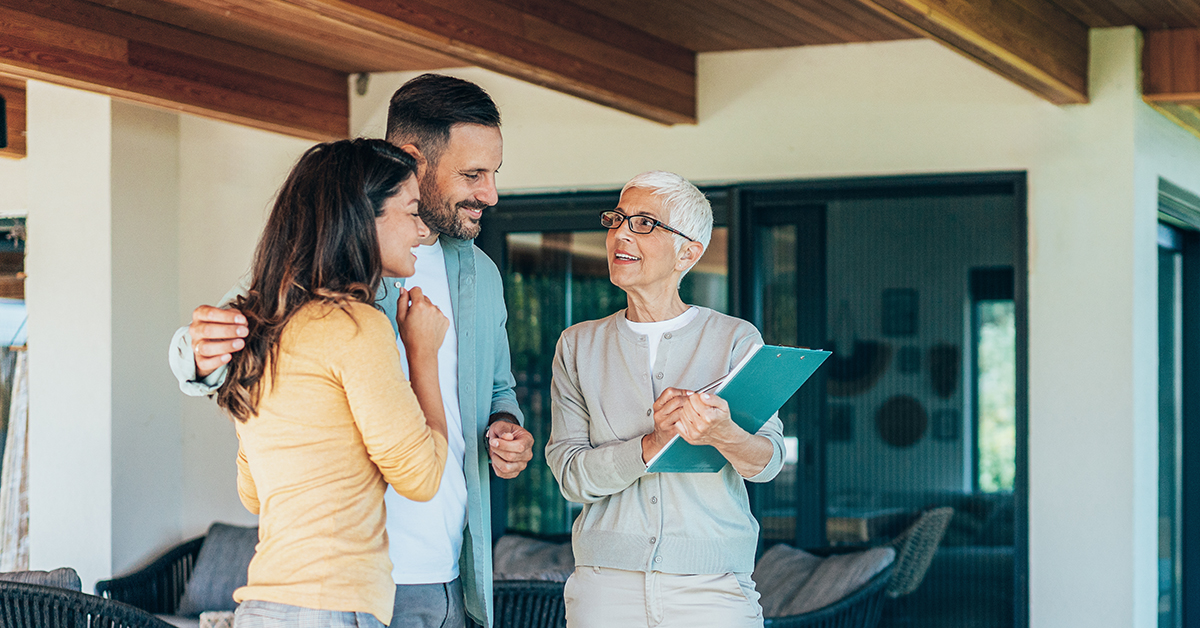 Real estate agent showing a house for sale to a couple